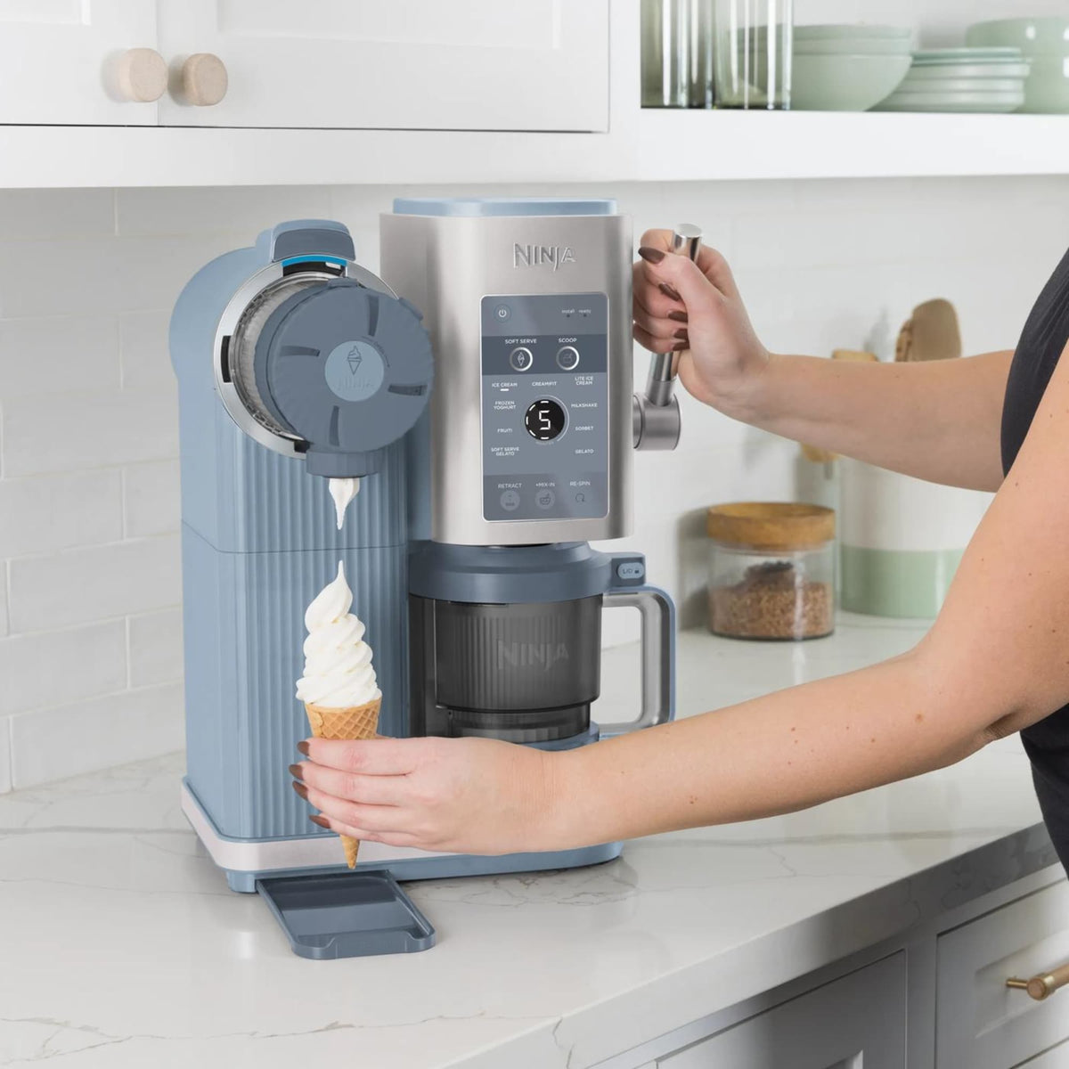 Ninja CREAMi Scoop & Swirl NC702EU dispensing swirled soft serve into a cone