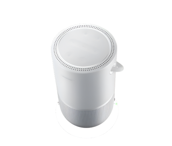 This image showcases the top view of a white Bose portable speaker, highlighting its smooth, rounded design with a perforated speaker grill on the upper portion for optimal sound dispersion. The compact, minimalist appearance is complemented by a handle on the side for easy portability.