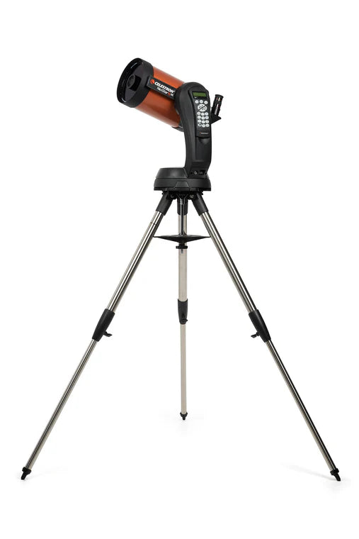 A Celestron NexStar 6SE telescope with an orange cylindrical tube mounted on a black computerized base and a silver tripod. The telescope is angled slightly upward for observation. The base features a control panel with a keypad for navigation and settings