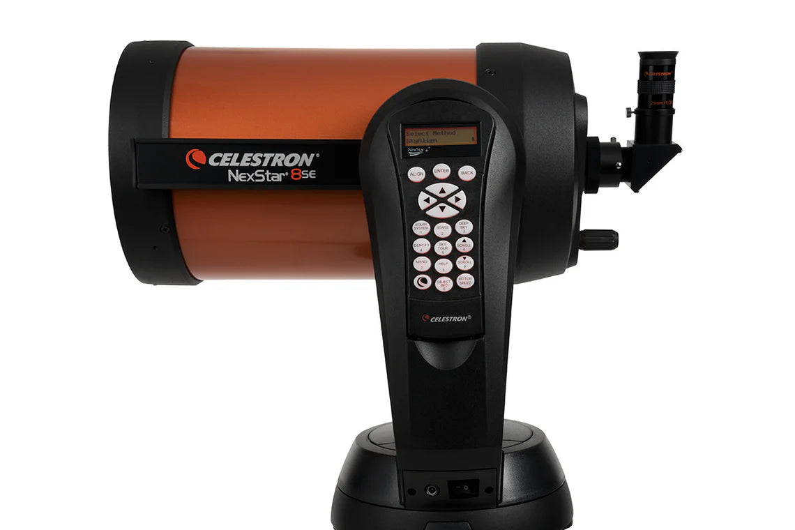  A Celestron NexStar 8SE telescope with an orange cylindrical tube mounted on a black computerized base. The base features a control panel with a keypad and a small display screen for navigation and settings. The eyepiece is attached to the back of the telescope tube, and the Celestron branding along with the model name "NexStar 8SE" is prominently displayed on the side of the tube. The telescope is designed for astronomical observation with advanced tracking and alignment capabilities.