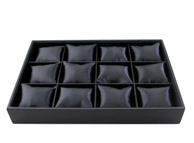 Black leather watch display tray with 12 cushioned slots for secure watch organization.