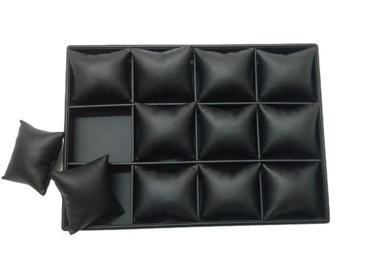 Black leather watch storage case with removable cushion inserts for organizing and protecting watches.