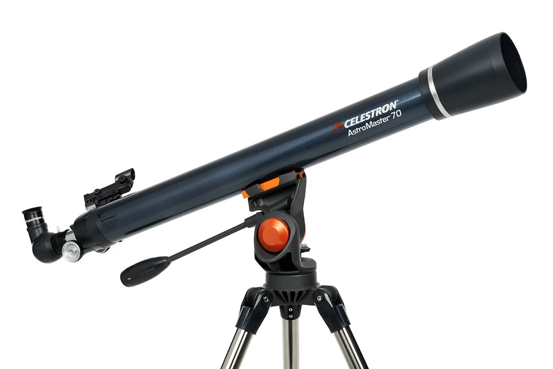 A Celestron AstroMaster 70AZ telescope with a long, blue cylindrical tube mounted on a gray altazimuth mount and silver tripod. The telescope is angled slightly upward for observation. The mount includes an orange adjustment knob and a control handle for positioning the telescope.