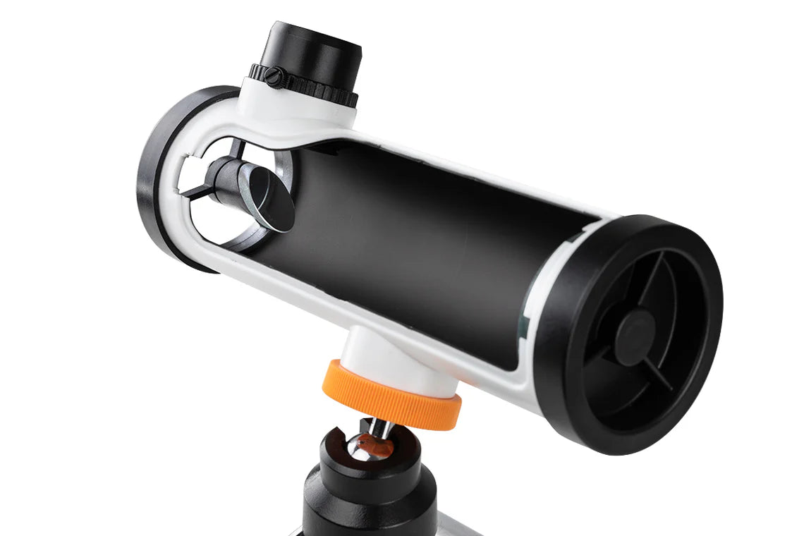 A close-up view of the Celestron Kids STEM 50mm Newtonian Telescope, showing the internal structure. The telescope's white cylindrical tube is partially cut away to reveal the internal mirror and lens assembly. The eyepiece is positioned at the top of the tube. The telescope is mounted on a small tripod with silver legs, a black mount, and an orange adjustment knob for positioning