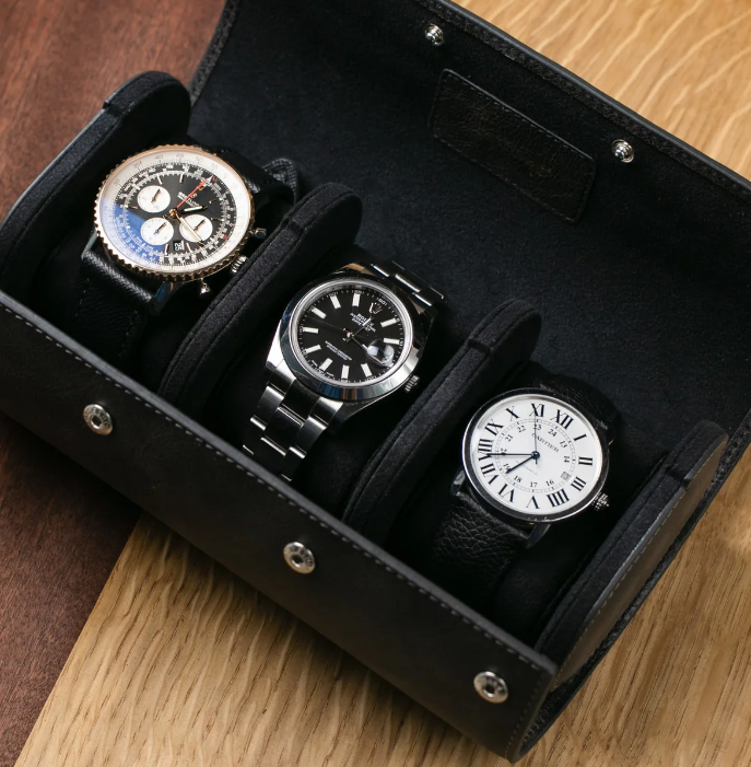 Luxury watch roll case displaying three classic timepieces, perfect for elegant watch organization and travel