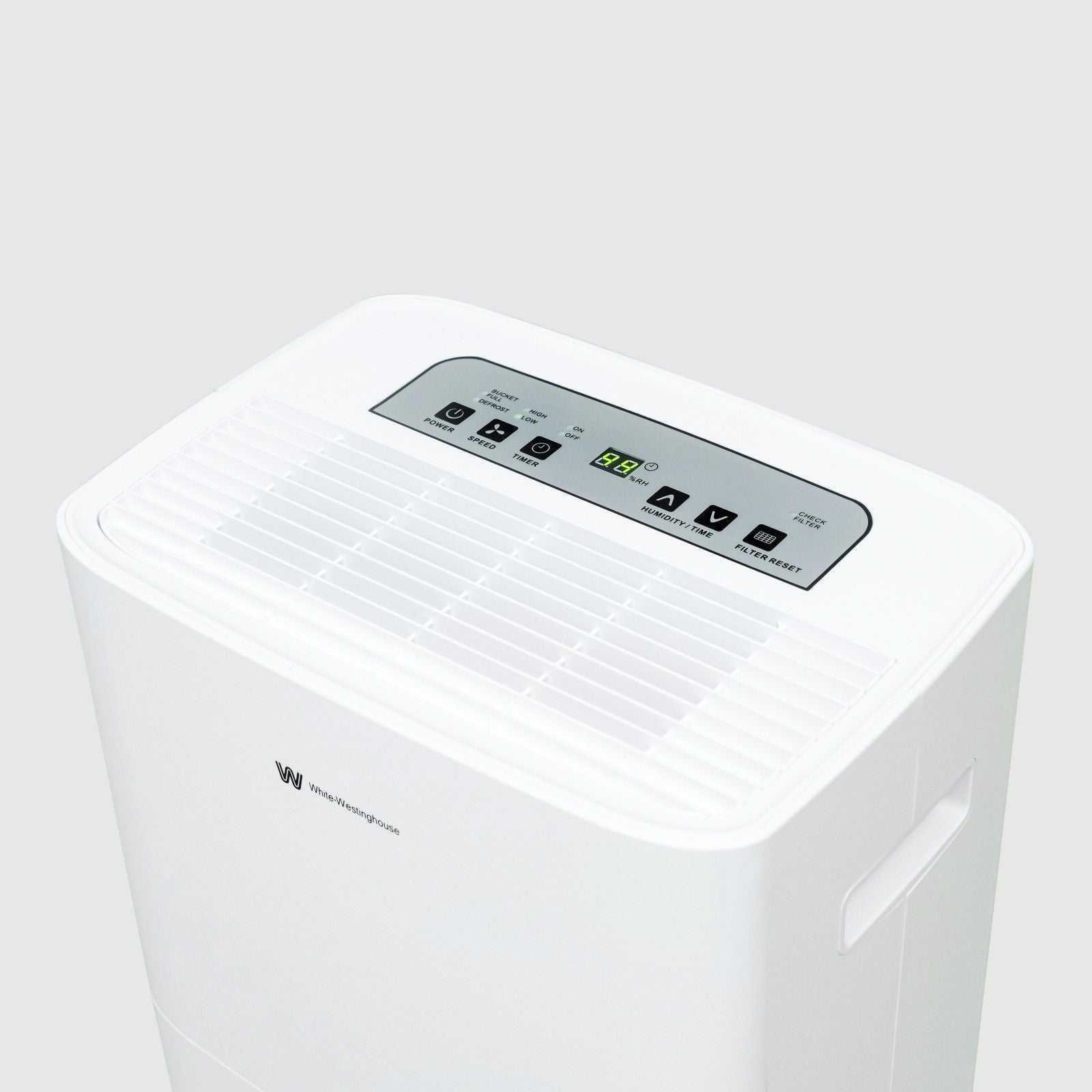 The top view of a white dehumidifier showing the control panel and air vent. The control panel includes various buttons for settings, a digital display showing the current humidity level, and indicators for different modes. The White-Westinghouse logo is visible on the front panel, and a built-in handle is seen on the side.