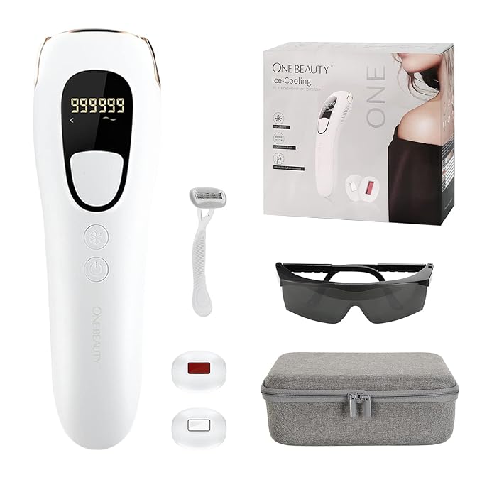 A set of beauty products from ONE BEAUTY, featuring an ice-cooling handheld device with a digital display showing "999999" on a black screen. The set includes a small razor, protective glasses, two additional device heads, a grey carrying case, and the product's packaging box. The packaging box displays an image of the handheld device and some of its features. The design emphasizes a complete, portable beauty solution.