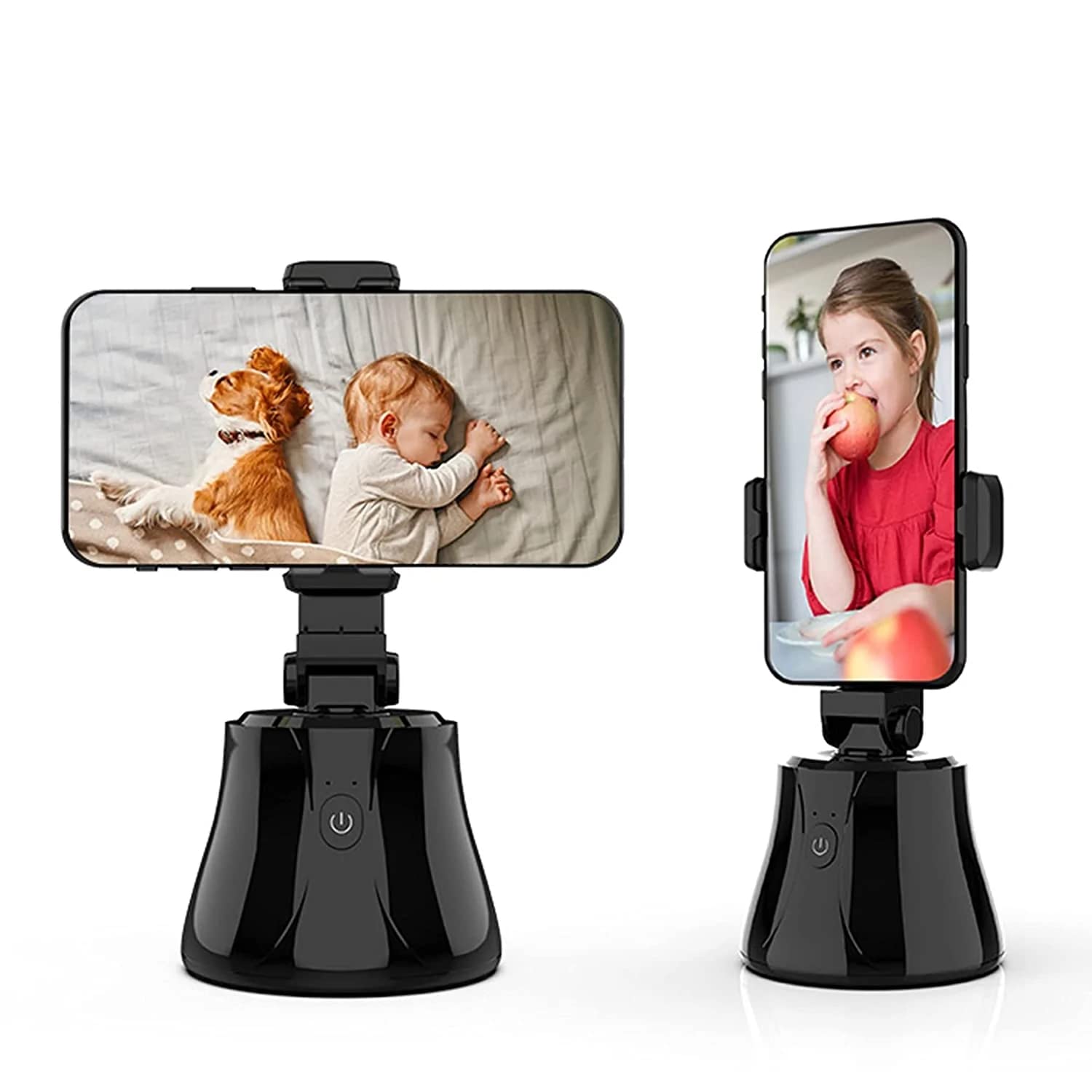 Two smart selfie sticks with smartphones mounted on them. The device on the left holds a phone in landscape orientation displaying a photo of a baby sleeping next to a dog. The device on the right holds a phone in portrait orientation showing a girl eating an apple. Both devices have sleek black bases with power buttons on the front.