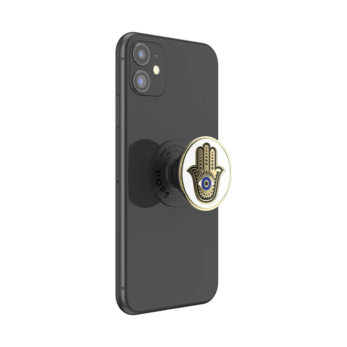 A black smartphone with a PopSocket attached to the back. The PopSocket features a design of a Hamsa hand with an eye in the center, similar to the previous images.