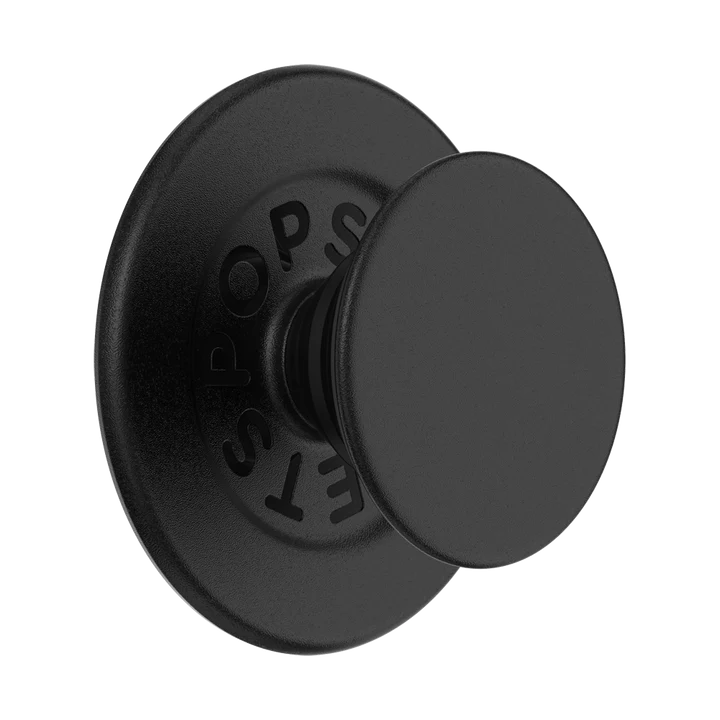 A PopGrip MagSafe in black is shown against a plain background. The grip features a round, flat surface with a matte black finish and the PopSockets logo embossed on the inner ring. The design includes a black base and an extendable grip, giving the PopGrip a sleek and modern appearance. The grip is designed to be compatible with MagSafe technology, allowing for easy attachment and removal from a MagSafe-compatible device.