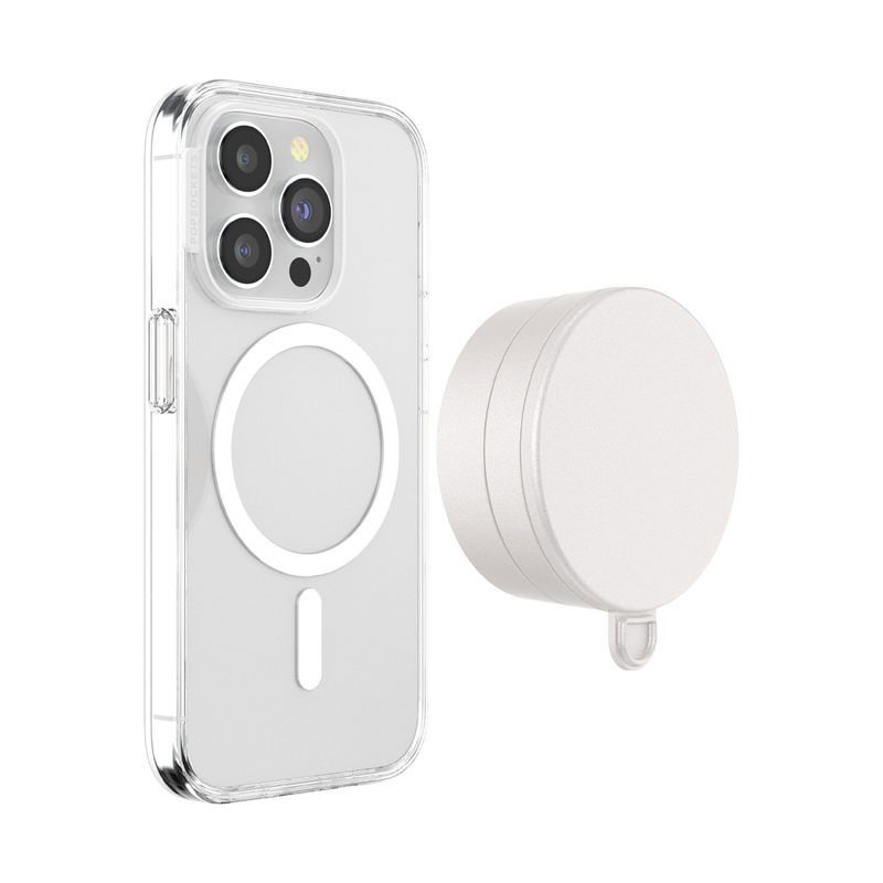 Clear smartphone case with a visible MagSafe ring next to a PopSockets Suction Mount for MagSafe in Horchata color. The mount has a circular design with a flat suction surface on one side and is shown from an angle. The smartphone and mount are displayed on a white background, highlighting their compatibility and design feature