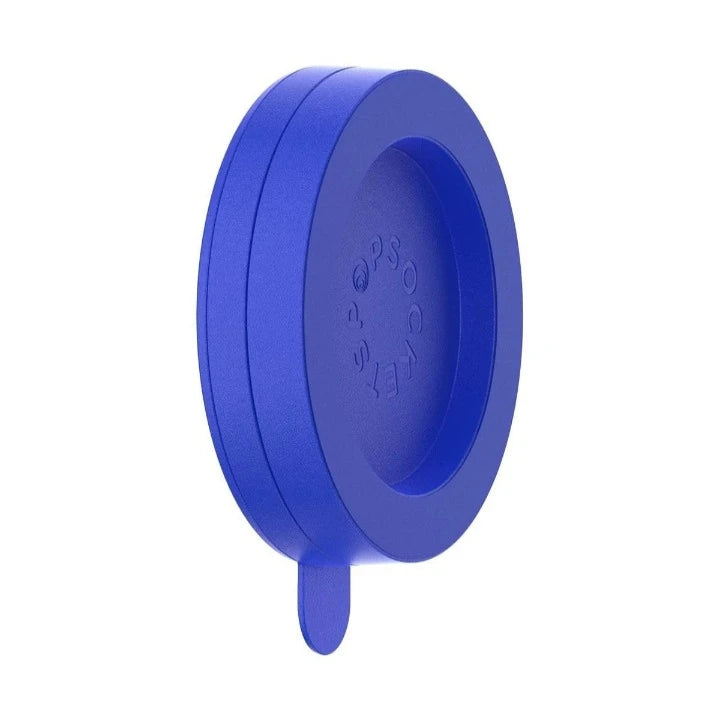 A PopSockets Suction Mount for MagSafe in cobalt blue is shown against a plain background. The mount features a circular design with the PopSockets logo embossed on the inner surface. A small tab extends from the bottom, likely for easy removal or adjustment. The vibrant cobalt blue color emphasizes the mount's stylish and functional design.