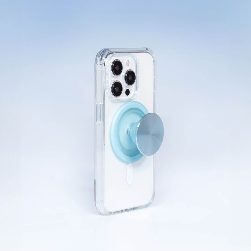 A smartphone with a clear case is shown with a PopSockets MagSafe PopGrip in blue sigh color attached to its back. The PopGrip is extended, showcasing its functional grip, with a glossy, slightly reflective soft blue surface. The phone's camera lenses are visible at the top, highlighting the PopGrip's sleek and modern design, which complements the phone's aesthetics while providing a practical grip for easier handling.