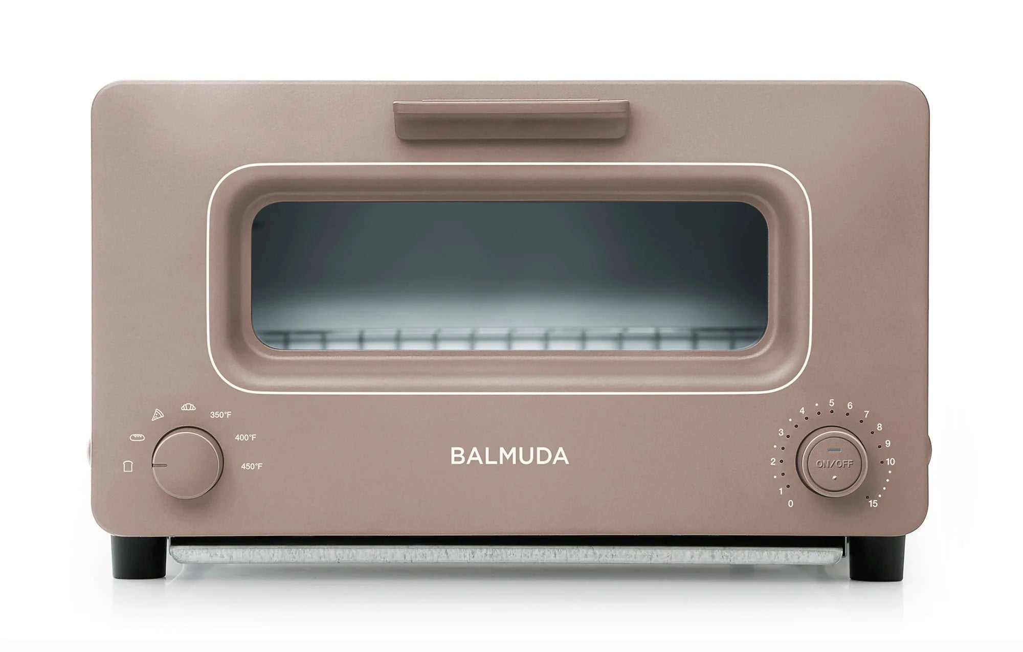 The image shows a front view of the Balmuda toaster in a soft, matte beige finish. The toaster features a large rectangular viewing window, framed by a matching beige accent. The brand name "BALMUDA" is centered in silver lettering below the window.