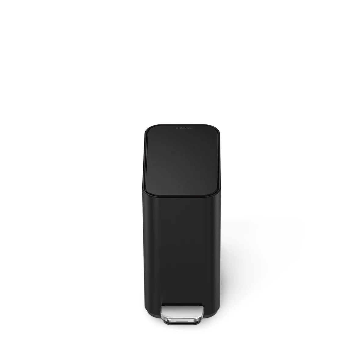 The image shows a front view of a black rectangular trash can with a minimalist design. The can features a foot pedal at the bottom front, made of a metallic material, likely stainless steel, which provides durability and a sleek contrast against the black body. The lid is closed, maintaining the trash can's clean, seamless appearance. The overall design is modern and understated, suitable for various environments where a functional yet stylish trash can is needed. The rectangular shape and compact size sug