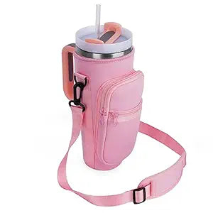 This is an image of a pink insulated tumbler holder with a straw-friendly lid, carrying handle, and an adjustable shoulder strap. It includes a zippered storage pocket, combining style with functionality for convenience while on the move. Let me know if you'd like any specific details!