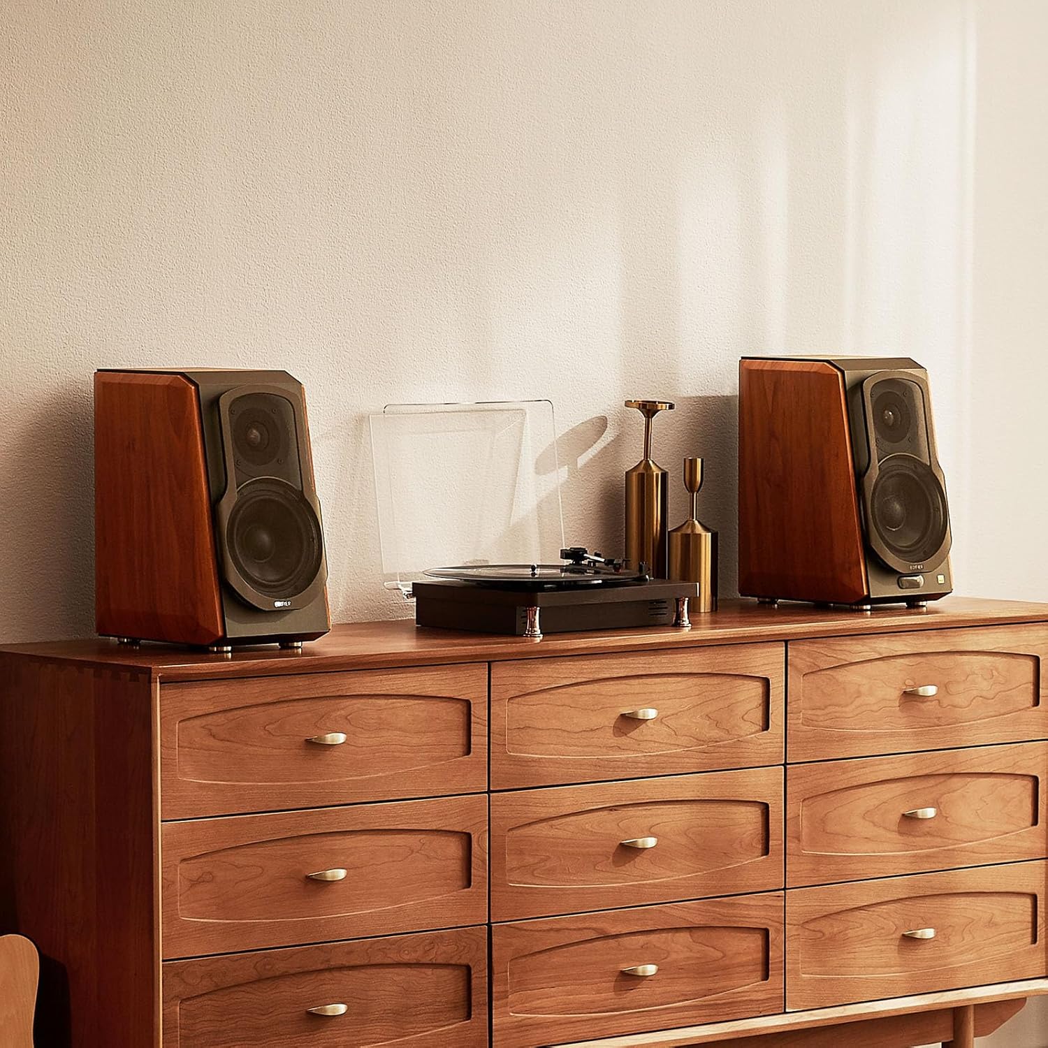 Pair of Edifier speakers with a wood finish set on a wooden dresser, flanking a turntable, creating a warm, vintage-inspired audio setup that combines classic style with modern sound quality.