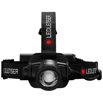  A front view of a black LED Lenser headlamp with an adjustable strap. The LED Lenser logo is visible on the strap. The headlamp features a prominent central light, adjustable for focus and direction. The background is white, highlighting the headlamp's design and details.