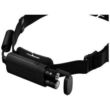 A black LED Lenser headlamp with an adjustable strap is shown with the battery compartment open, revealing two AA batteries inside. The coiled cable connects the battery pack to the headlamp unit. The LED Lenser logo is visible on the strap. The background is white, highlighting the headlamp's design and the accessible battery compartment.