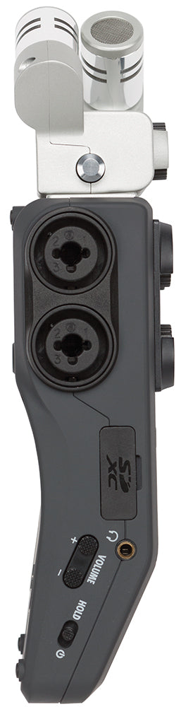 Side view of the Zoom H6 Handy Recorder, showcasing the dual XLR/TRS combo inputs, SDXC card slot, power switch, and mic gain controls for the attached XY microphone capsule.