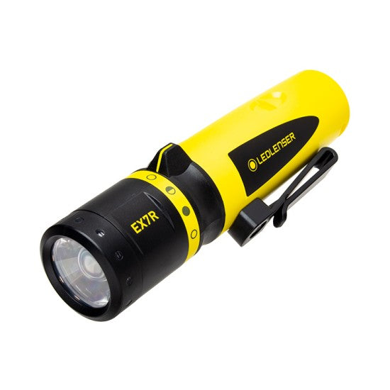  A yellow and black LED Lenser flashlight with a compact, cylindrical design, featuring a prominent lens at the front and a switch on the body. The model number "EX7R" is printed near the head of the flashlight. The flashlight also has a black clip attached to the side for easy carrying.