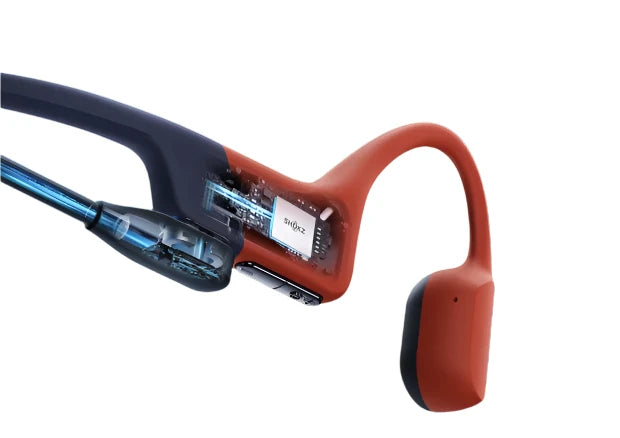 Cutaway view of Shokz bone conduction headphones in orange and navy, showcasing internal components and advanced technology for water-resistant, high-performance audio.