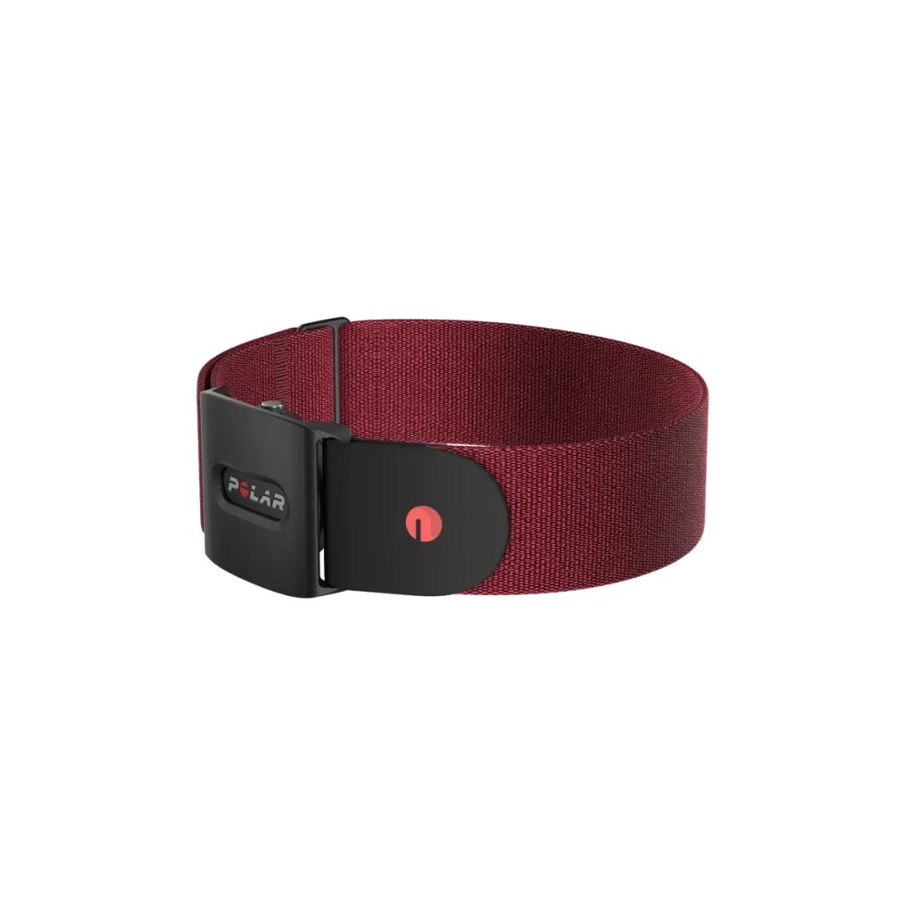  A Polar optical heart rate sensor with a black casing and a red adjustable strap. The front side of the sensor is visible, featuring the Polar logo and a red power button on its casing. The strap is designed for secure fitment around the chest and includes an adjustable buckle for a customized fit.