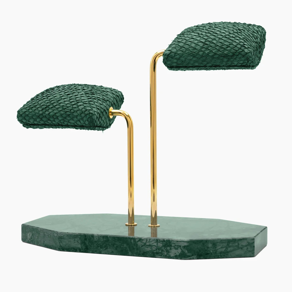  A display stand featuring two green textured cushions mounted on elegant gold curved supports. The base of the stand is a green marble slab with an irregular shape. The design is sophisticated and luxurious, ideal for showcasing wristwatches or similar items. The combination of the green cushions, gold supports, and marble base creates a refined and stylish presentation.