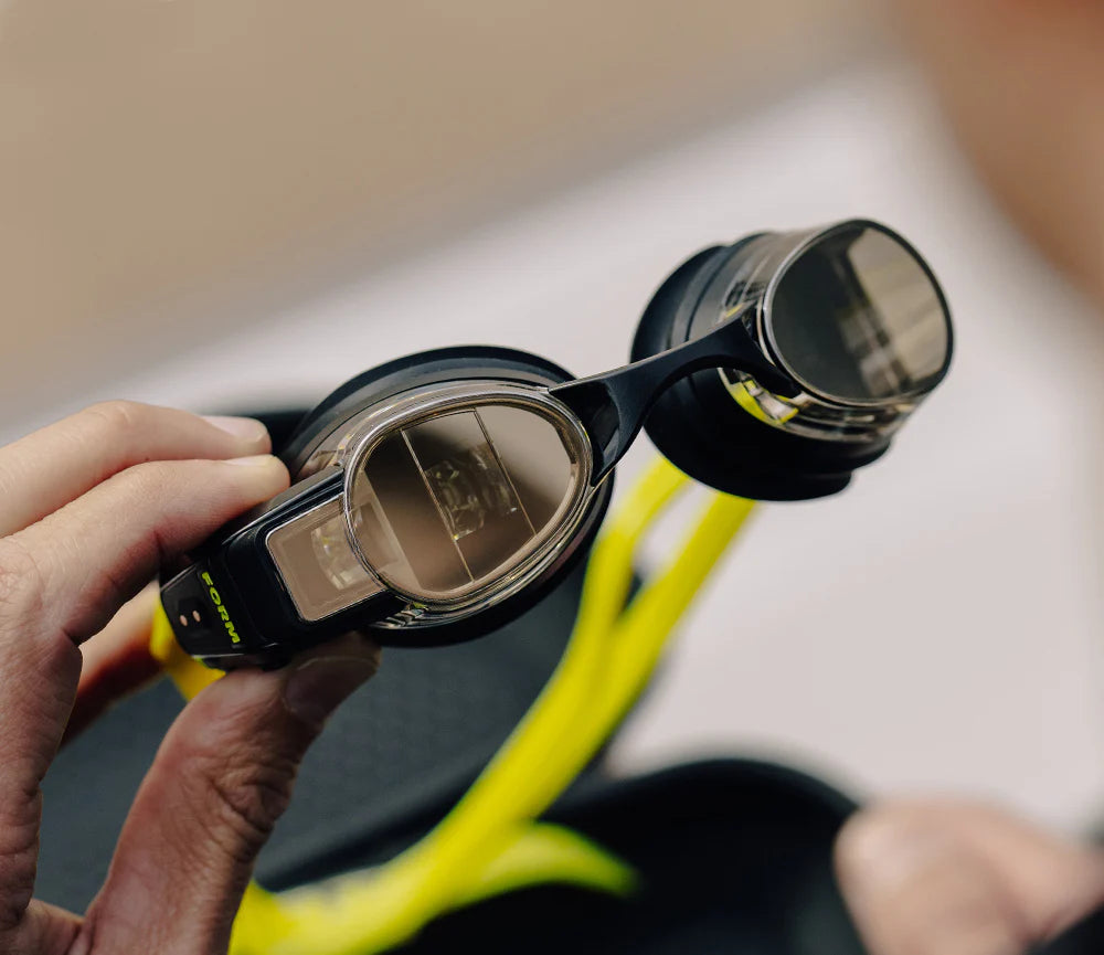 This image highlights the FORM Smart Swim Goggles' advanced design, showcasing the integrated display inside the lens that provides swimmers with real-time metrics such as time, distance, and pace while swimming.