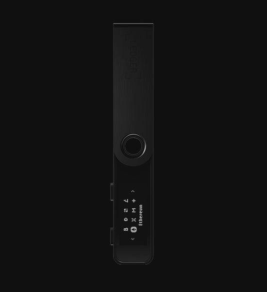 The image appears to be a still from a short video, showing the Ledger Nano S Plus, a hardware wallet used for securing cryptocurrencies. The device is displayed against a black background, emphasizing its sleek, all-black design. The screen on the device shows the word "Ethereum," indicating that it is currently displaying information related to the Ethereum cryptocurrency. The design is minimalistic and modern, in line with the brand's focus on security and cutting-edge technology.