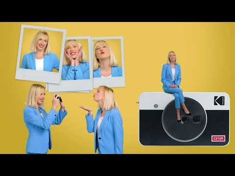 A promotional YouTube thumbnail for the **Kodak Mini Shot 2 - C210R Instant Camera**, featuring a woman in a blue suit interacting with the camera, playful instant photo cutouts, and a large image of the camera on a yellow background.