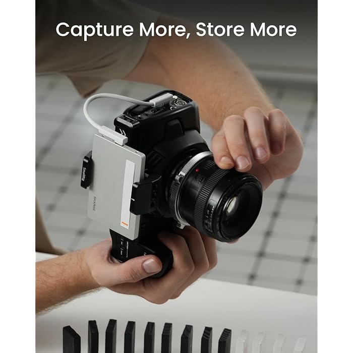 A photographer holding a professional camera equipped with a SHARGE power bank securely attached, connected via a white cable. The setup highlights the device's compatibility with cameras, ensuring extended power for capturing and storing more moments seamlessly.