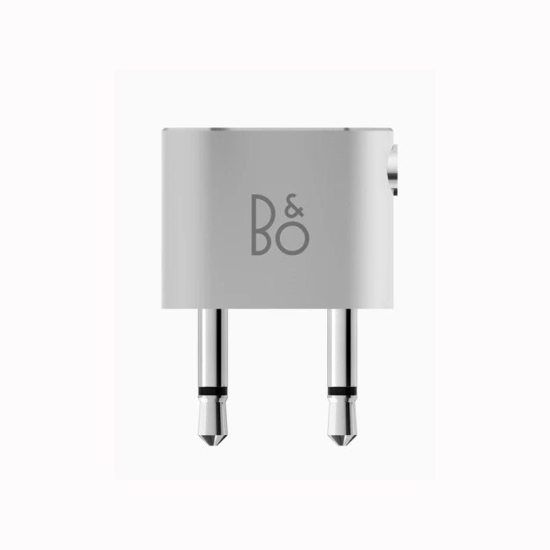 B&O dual airline adapter with metal prongs and sleek silver design for in-flight audio compatibility.